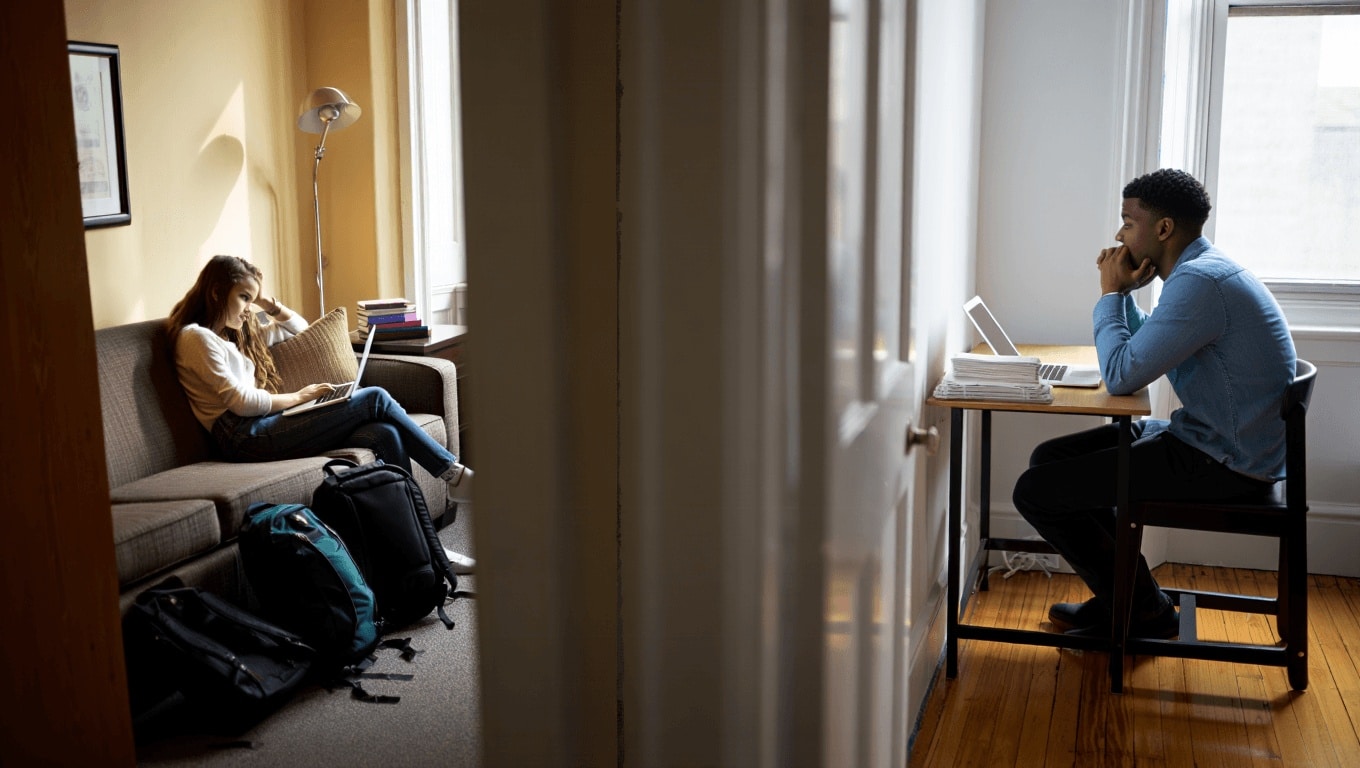 Three students sit in front of notes and laptops as they discuss the pros and cons of living on campus vs. off campus.