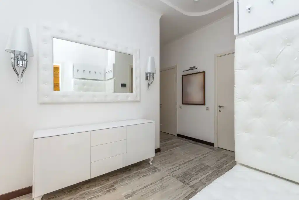 Petit appartement lumineux avec mobilier minimaliste et miroir reflétant la lumière naturelle