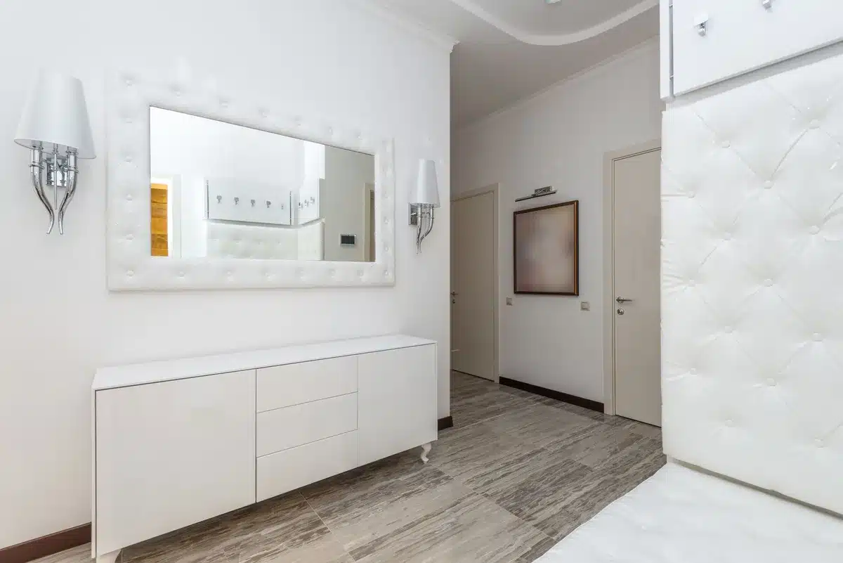 Petit appartement lumineux avec mobilier minimaliste et miroir reflétant la lumière naturelle