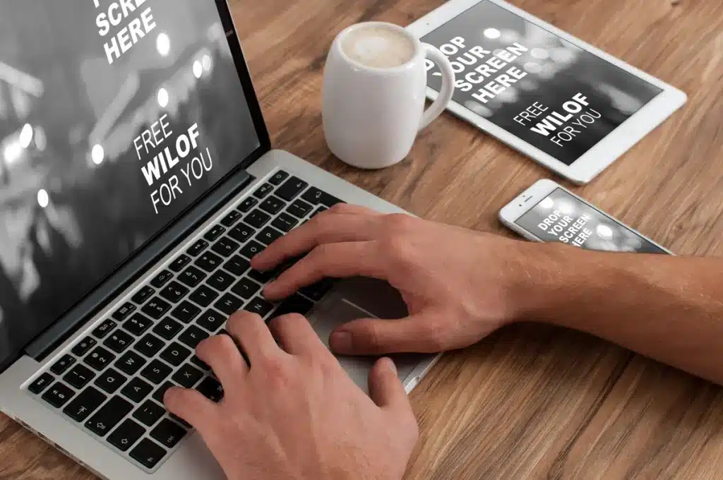 Espace de travail de freelance avec ordinateur portable, carnet et café sur un bureau bien éclairé