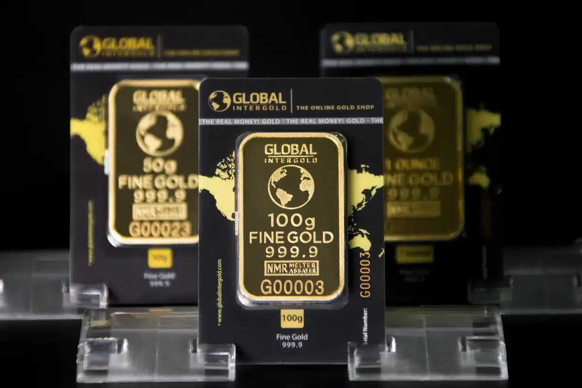 Lingot de platine brillant tenu en main, environnement industriel en arrière-plan