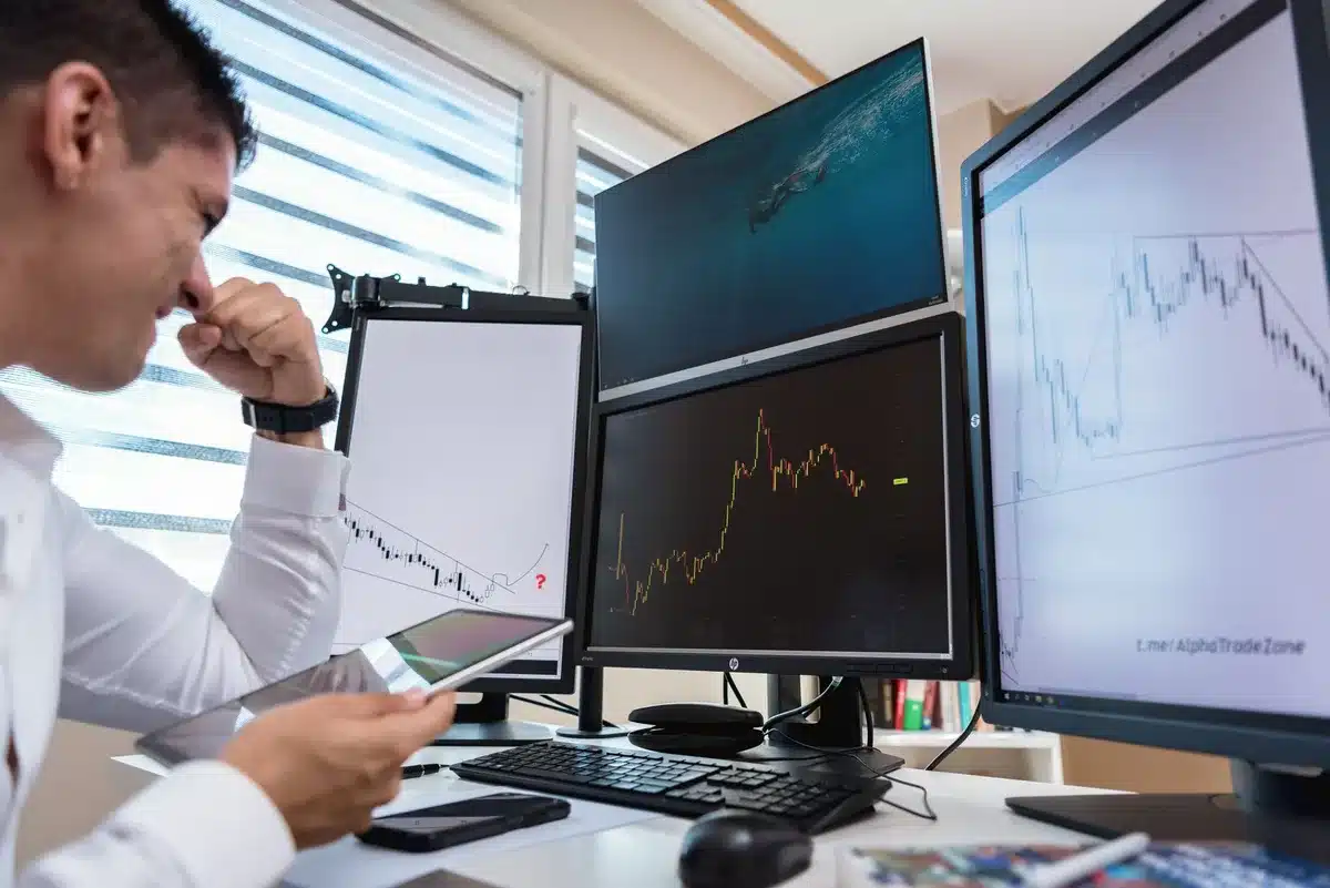 Analyste financier devant plusieurs écrans affichant des graphiques de rotation sectorielle et des courbes de tendance.