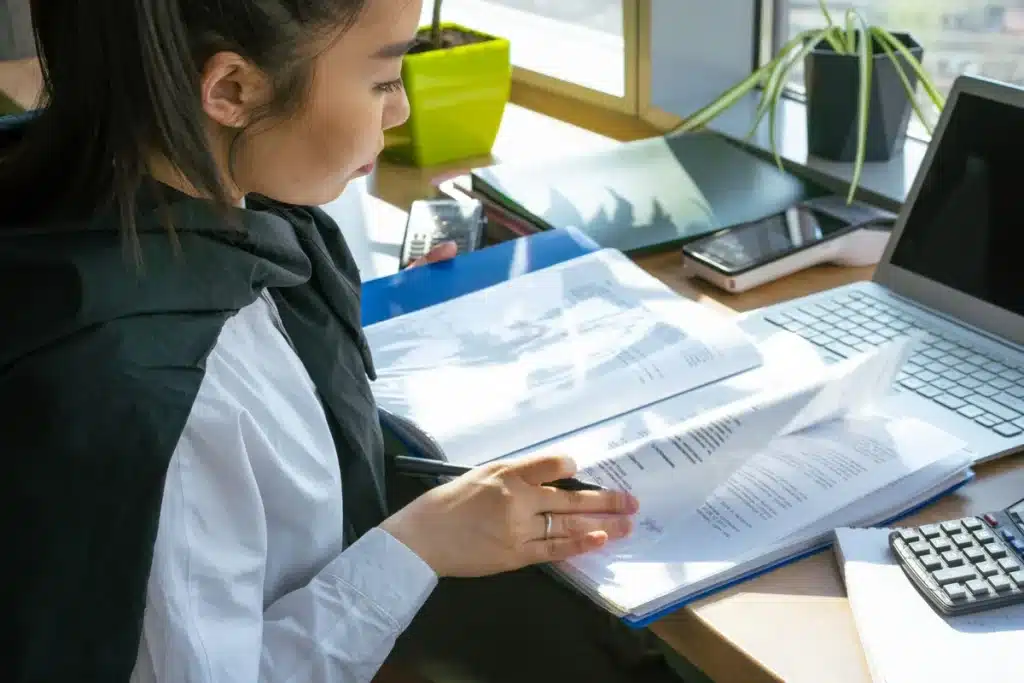 Étudiant consultant des documents de location et un passeport sur un bureau