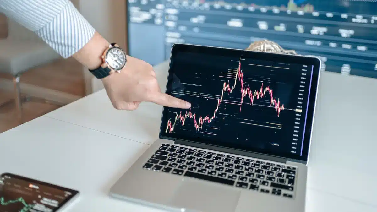 Tableau de bord financier affichant les indices boursiers en hausse avec des graphiques en mouvement ascendant.