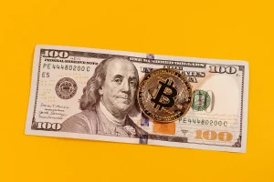Pièces numériques et billets de dollar fusionnant dans des nœuds blockchain sur un écran lumineux