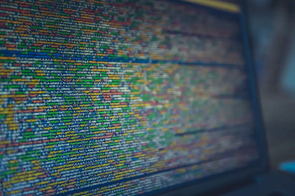 Mains anonymes d'un développeur devant un clavier d'ordinateur portable avec des nœuds de réseau blockchain en arrière-p