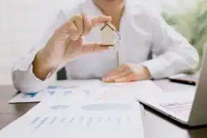 Documents immobiliers et contrats de location sur un bureau avec une main examinant les options de transition