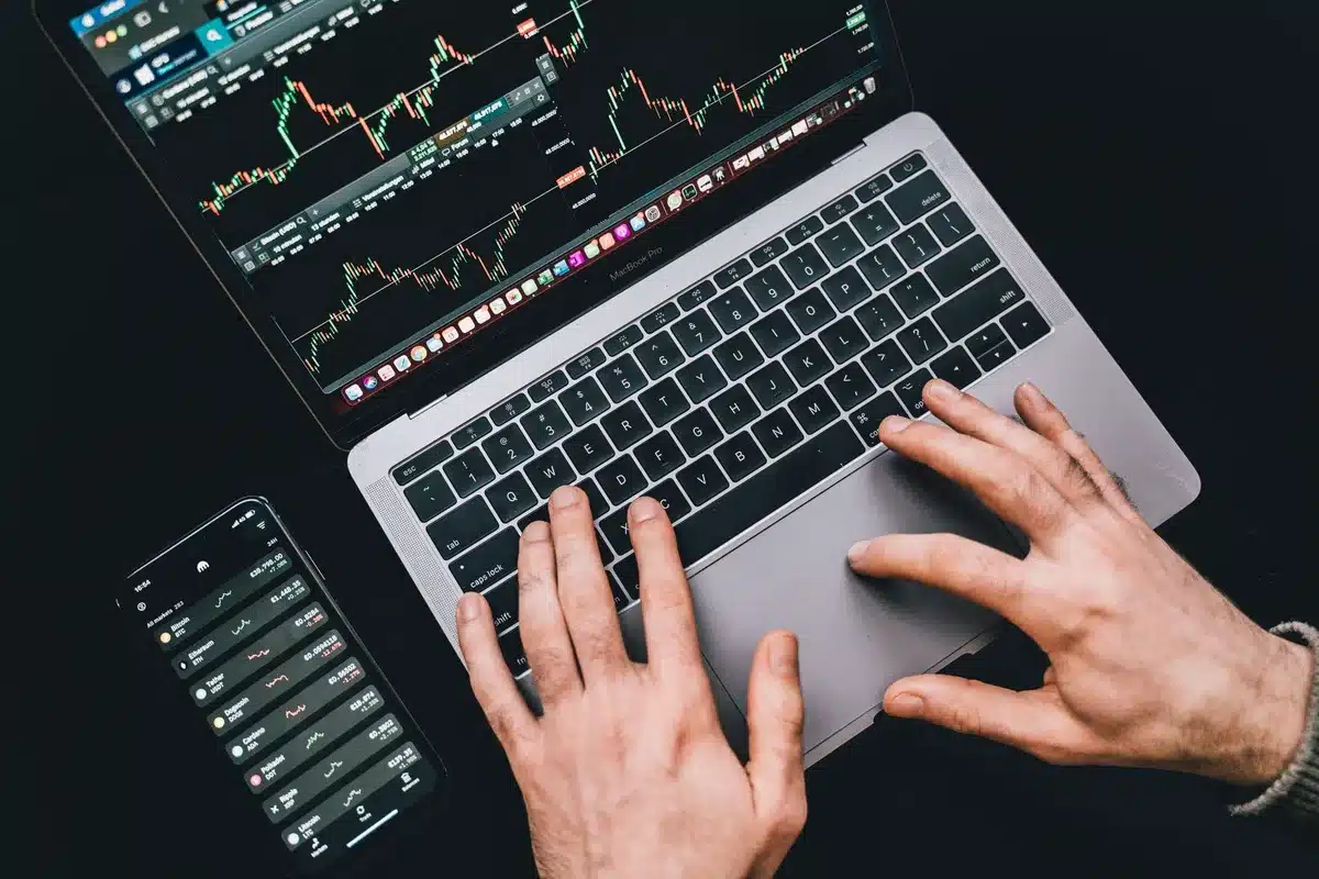 Poste de trading avec plusieurs écrans affichant des graphiques boursiers et indicateurs techniques