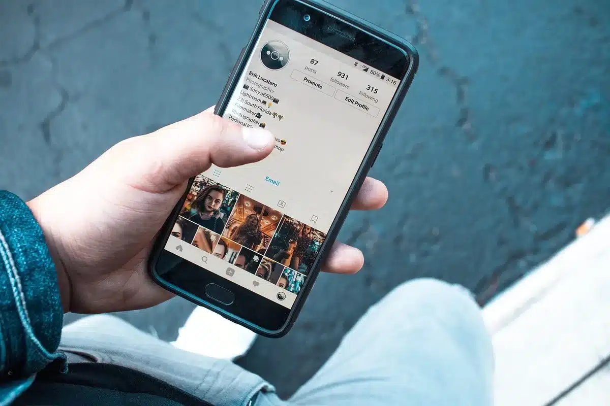 Smartphone tenu par des mains montrant une application mobile en fonctionnement