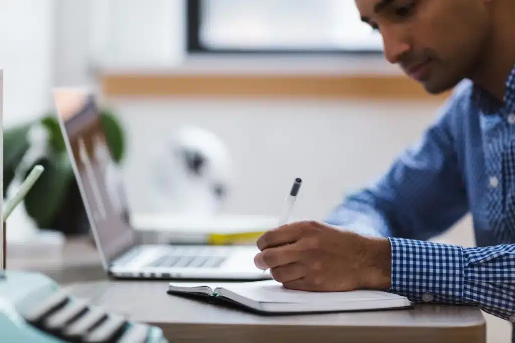 Silhouette d'une personne triant des documents et un ordinateur portable sur une table