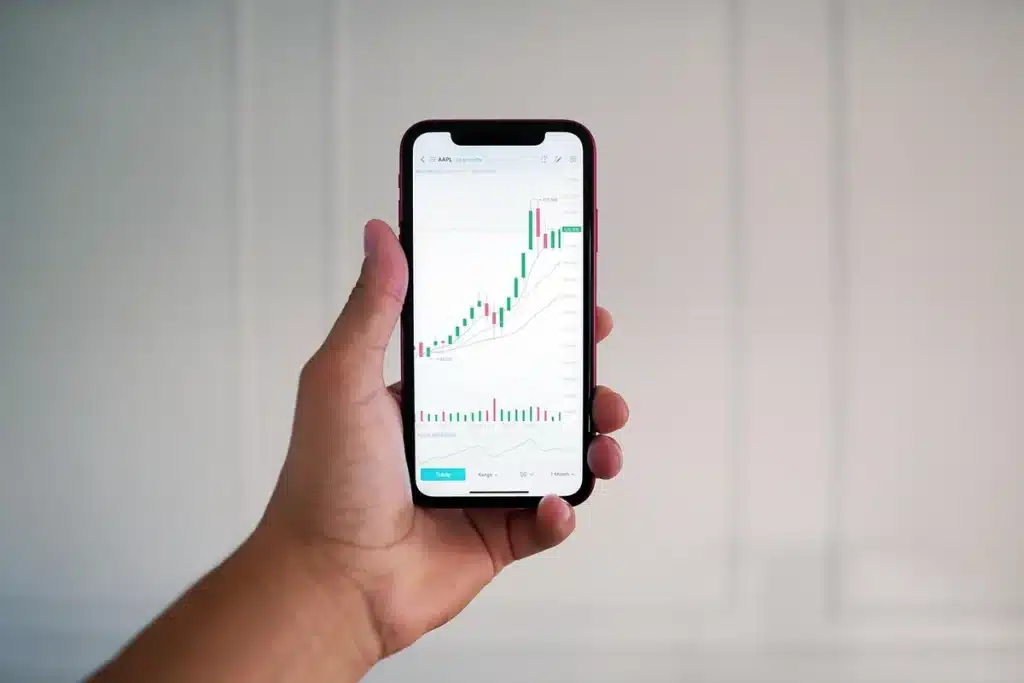 Silhouette d'un trader face à des écrans montrant graphiques boursiers et volumes