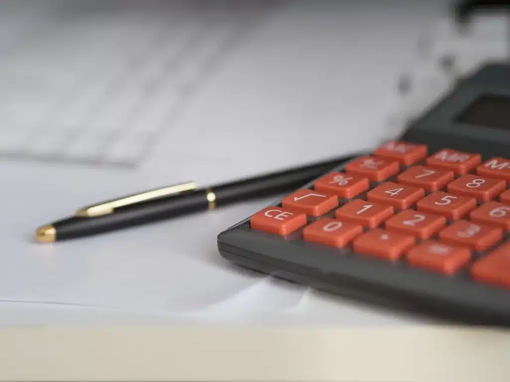 Mains tenant des placements atypiques (diamants, vin, énergie solaire) avec documents financiers sur un bureau