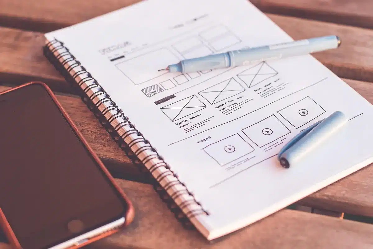 Bureau lumineux avec ordinateur portable, carnet et mains posant un document