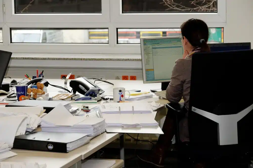 Mains tenant un CV et un calendrier sur un bureau avec un ordinateur portable et du café