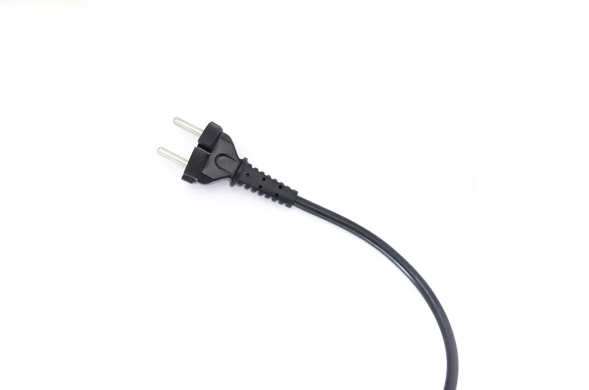 Personne testant une prise électrique avec un chargeur pour vérification
