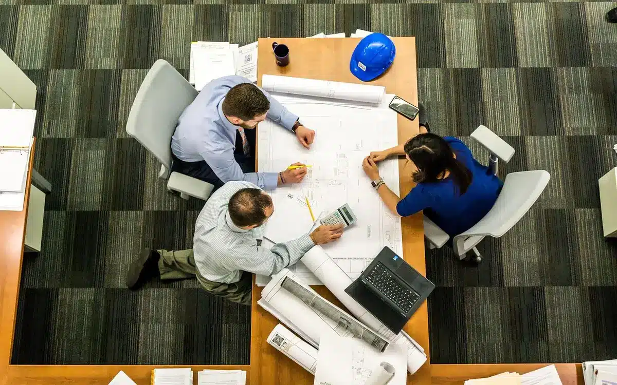 Collaborateurs discutant ensemble autour d'une table de réunion