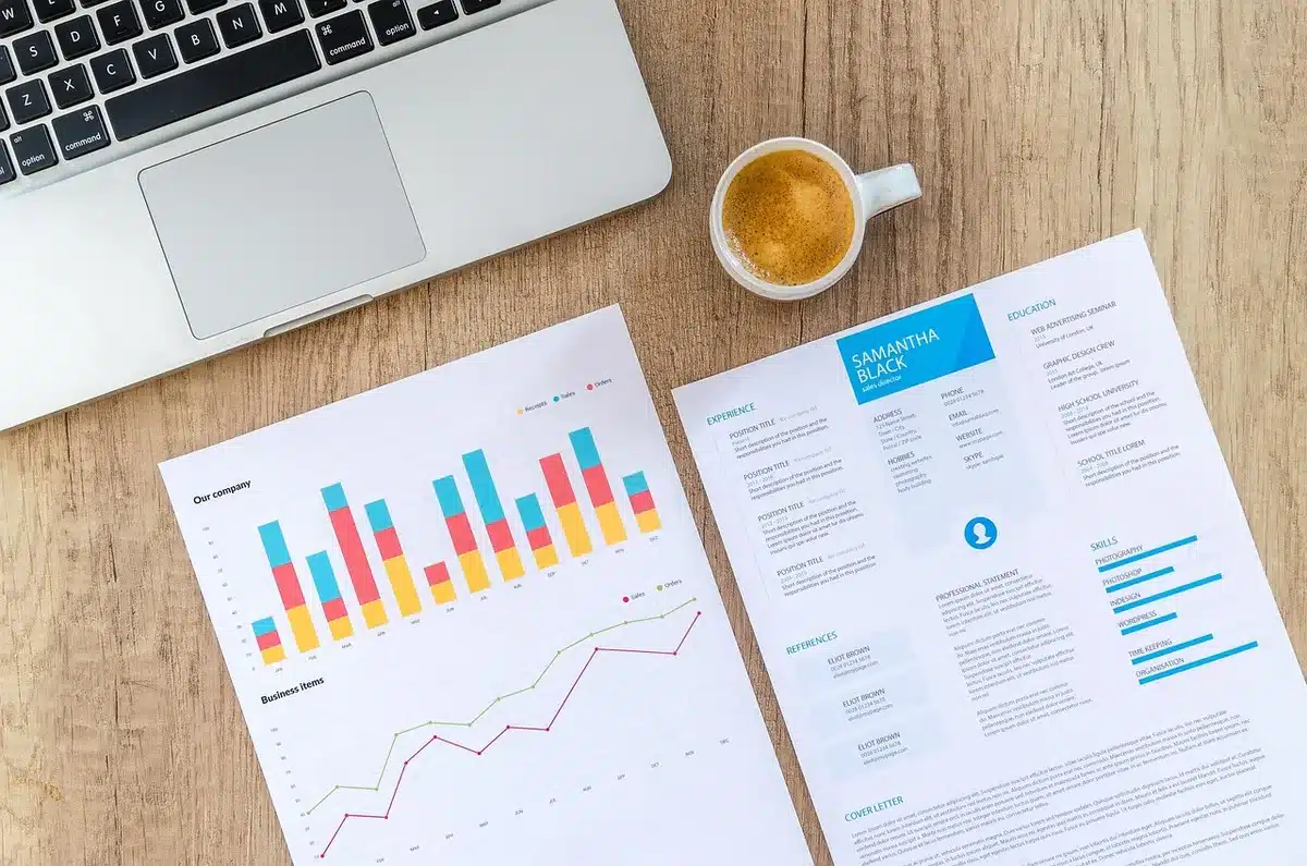 Bureau ensoleillé avec ordinateur portable, graphiques crypto et bloc‑notes