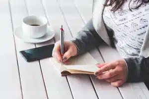 Bureau en lumière du jour avec feuille de budget, calculatrice et mains anonymes