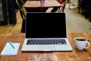 Bureau lumineux avec carnet, mains prenant des notes et calculatrice