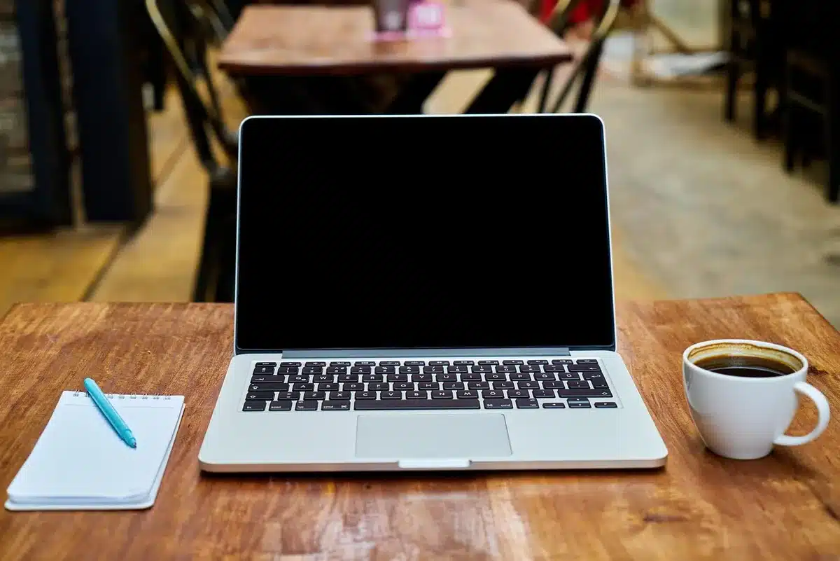 Bureau lumineux avec carnet, mains prenant des notes et calculatrice