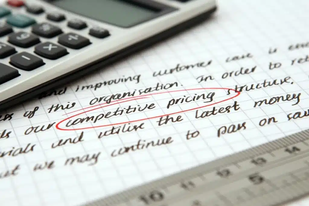 Bureau à domicile en journée, mains triant des papiers et calculatrice sur le bureau