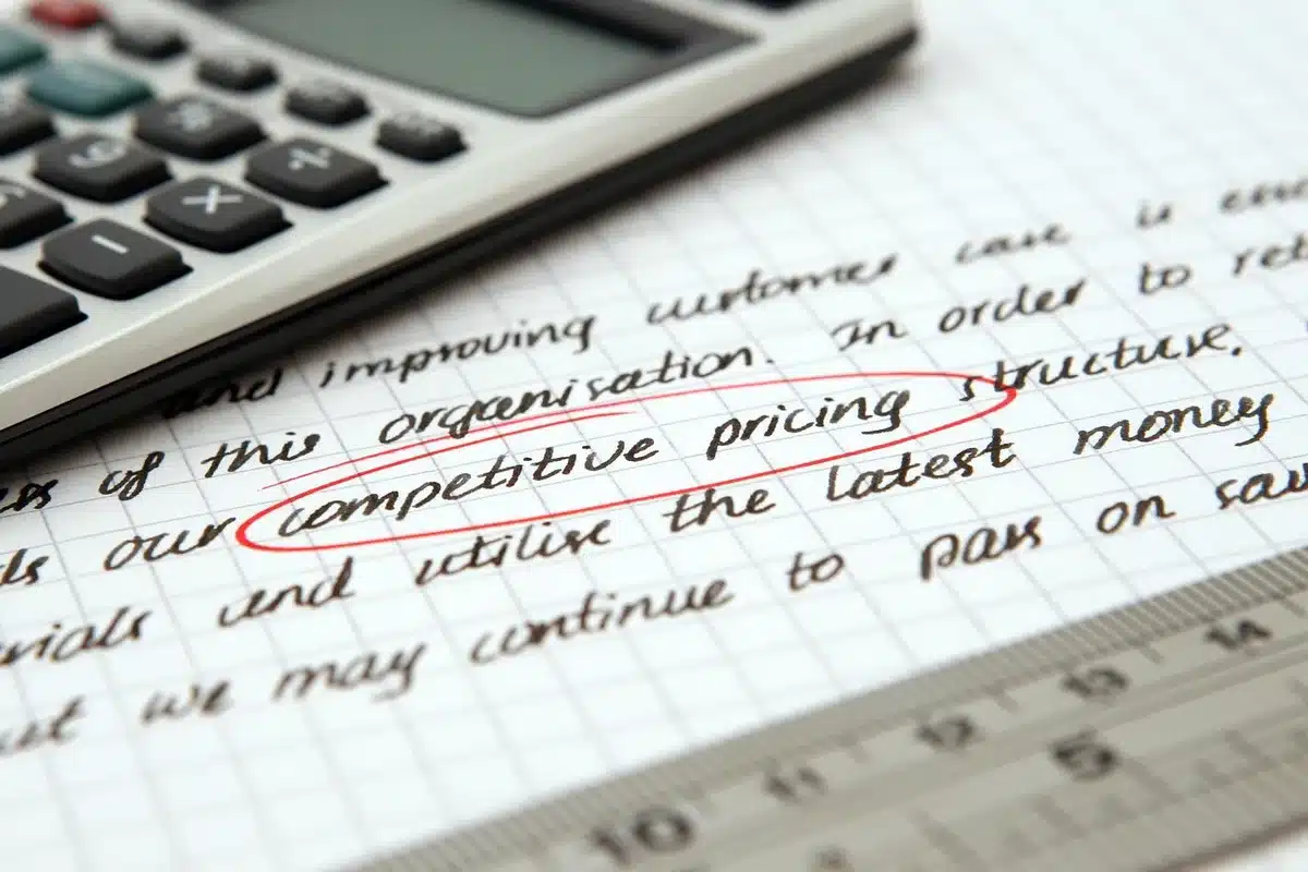 Bureau à domicile en journée, mains triant des papiers et calculatrice sur le bureau