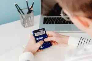 Bureau de trading en journée avec mains, carnet et calculatrice