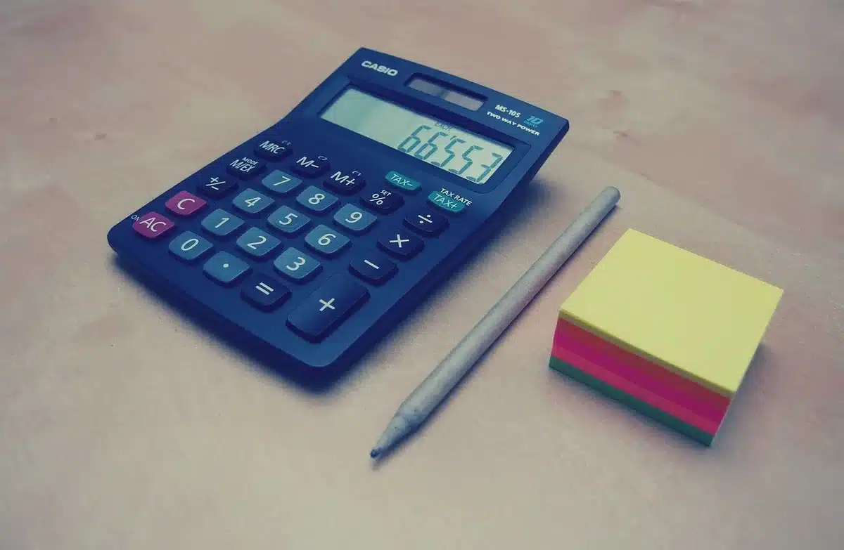 Bureau lumineux avec feuilles de budget et calculatrice près d'une fenêtre en journée
