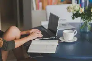 Bureau en journée avec calculatrice et carnet de budget près d’une fenêtre