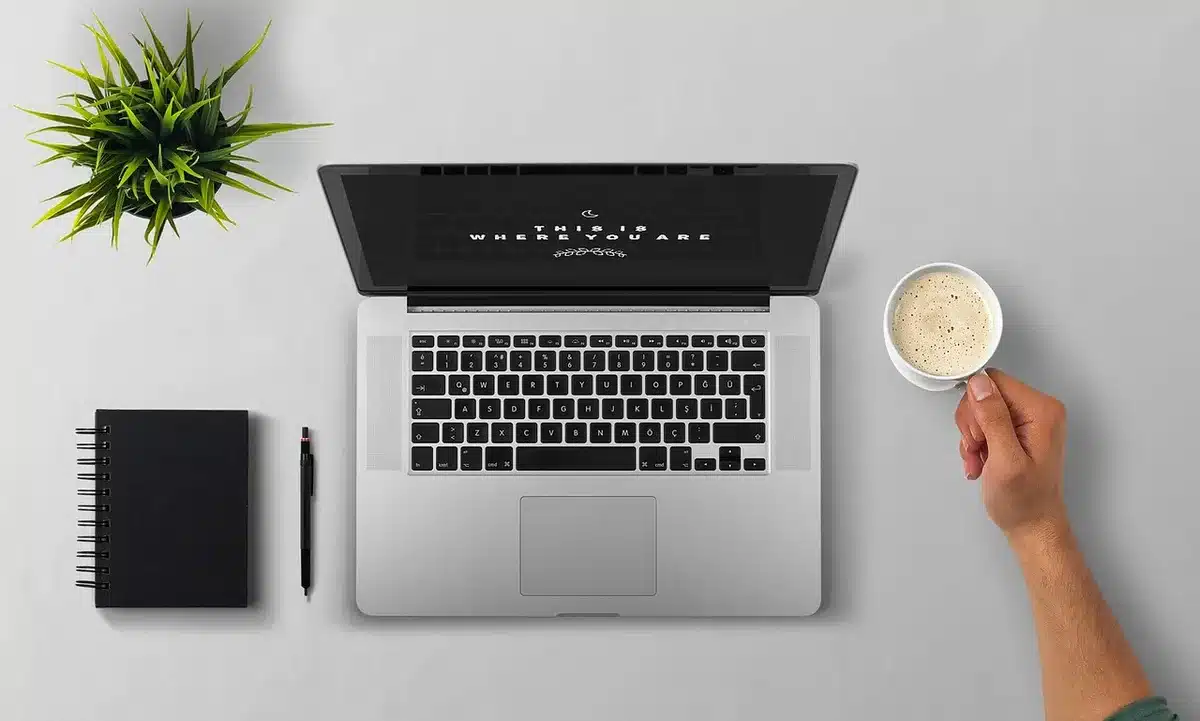 Carnet de notes avec checklist de setup de trading à côté d'un ordinateur