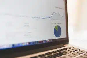 Bureau lumineux avec graphiques financiers et mains anonymes travaillant