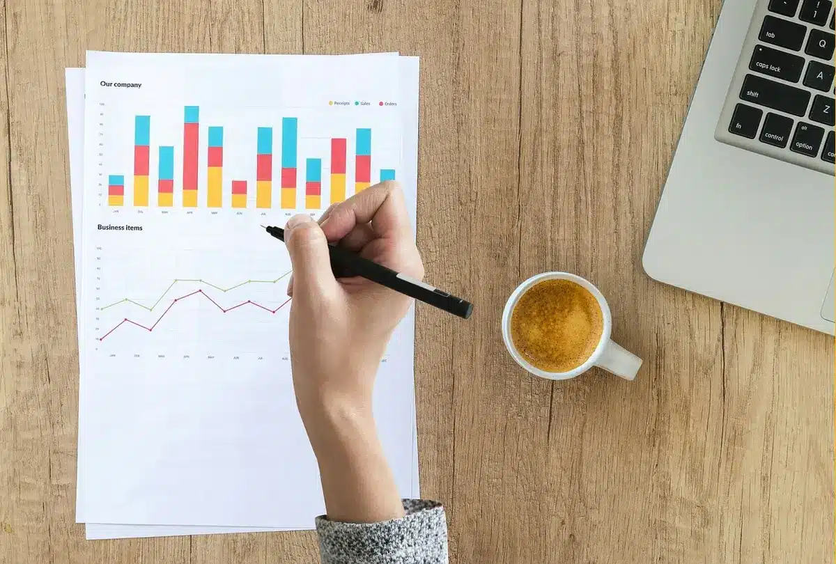 Bureau ensoleillé avec graphiques financiers et mains consultant des feuilles