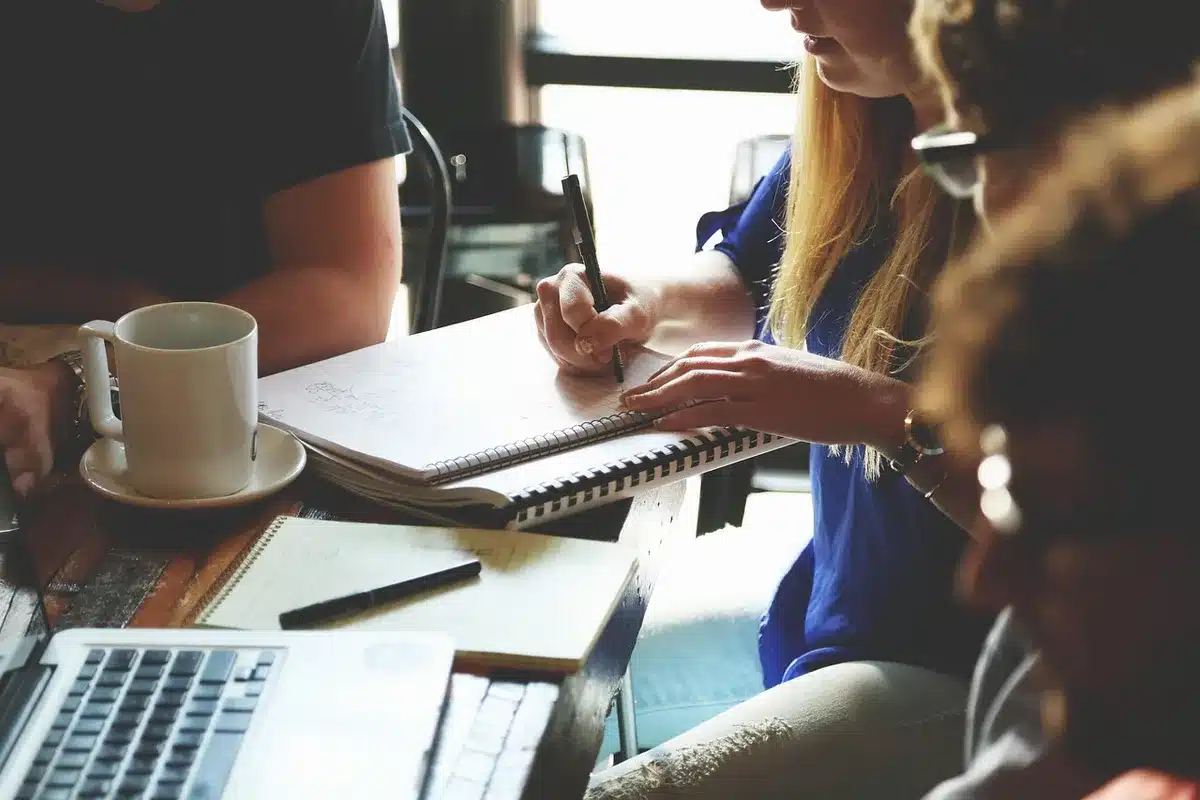 Personnes anonymes autour d'une table discutant de projets crypto