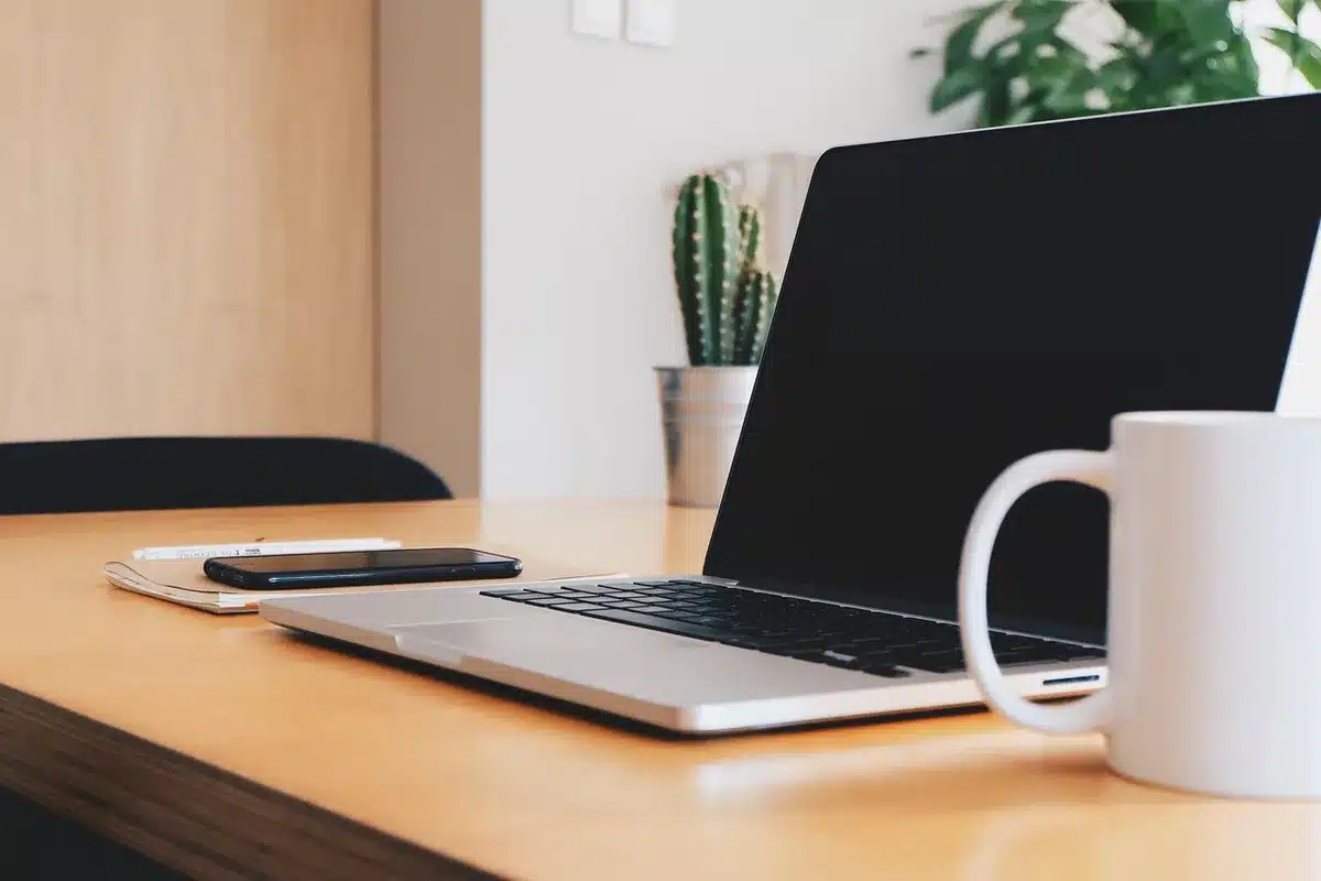 Bureau de développeur avec ordinateur portable et documents blockchain, lumière du jour