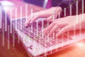 Bureau de trading en lumière du jour avec graphiques flous, calculatrice et mains