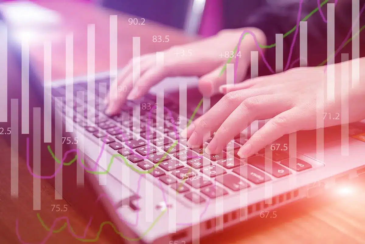 Bureau de trading en lumière du jour avec graphiques flous, calculatrice et mains